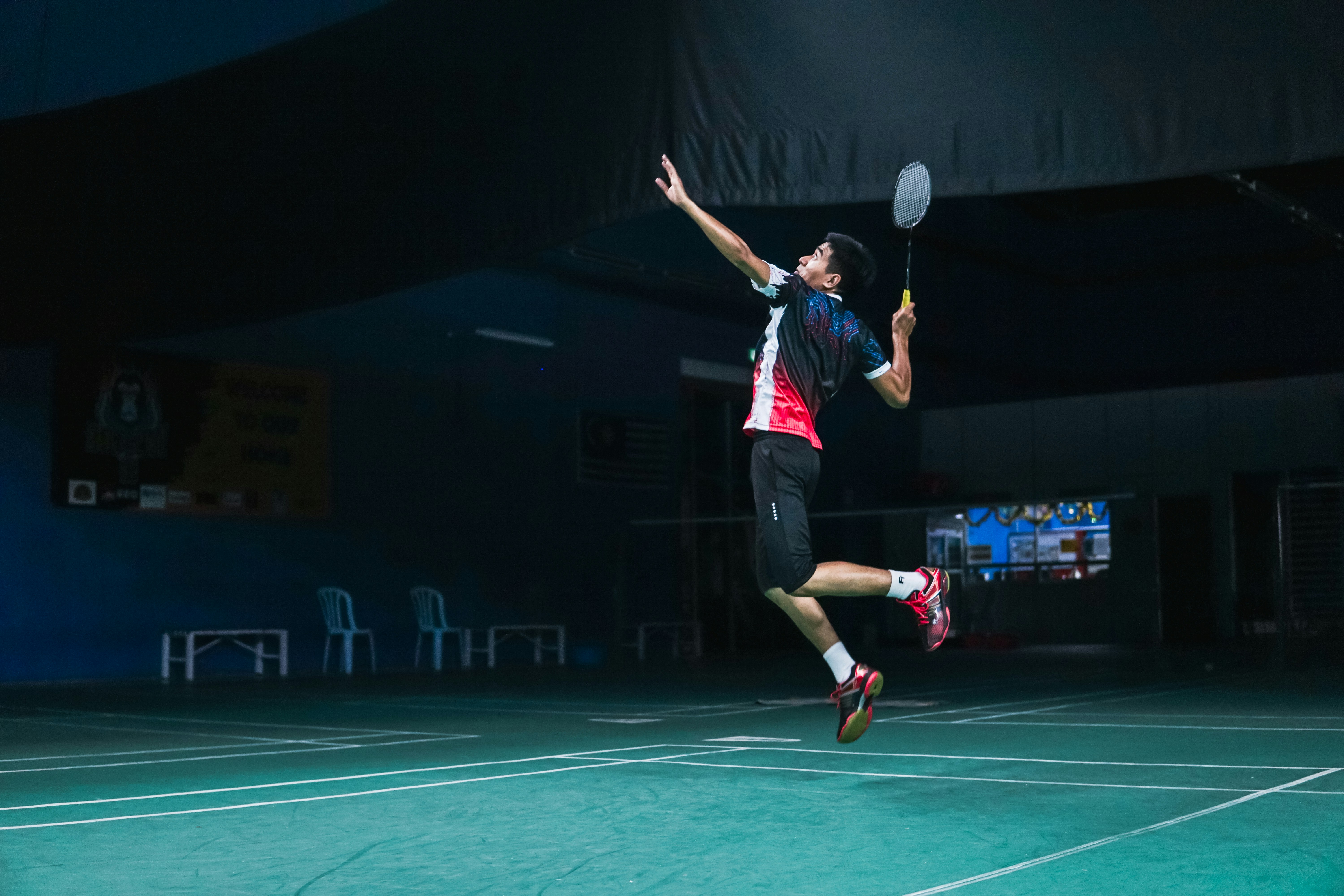 Young badminton player smashing shuttlecock